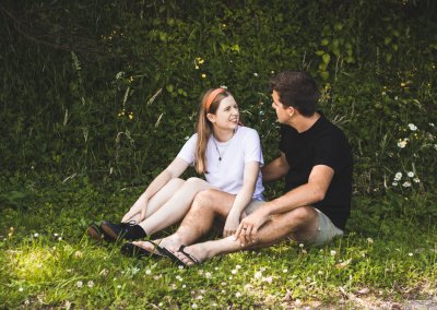 A young couple sitting in the grass talking