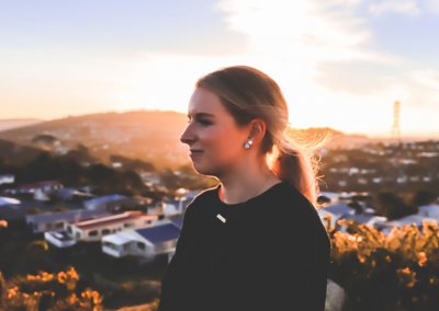 A side profile of a young woman at sunset