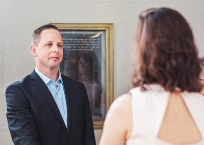 A man during his wedding ceremony looking at his wife, smiling